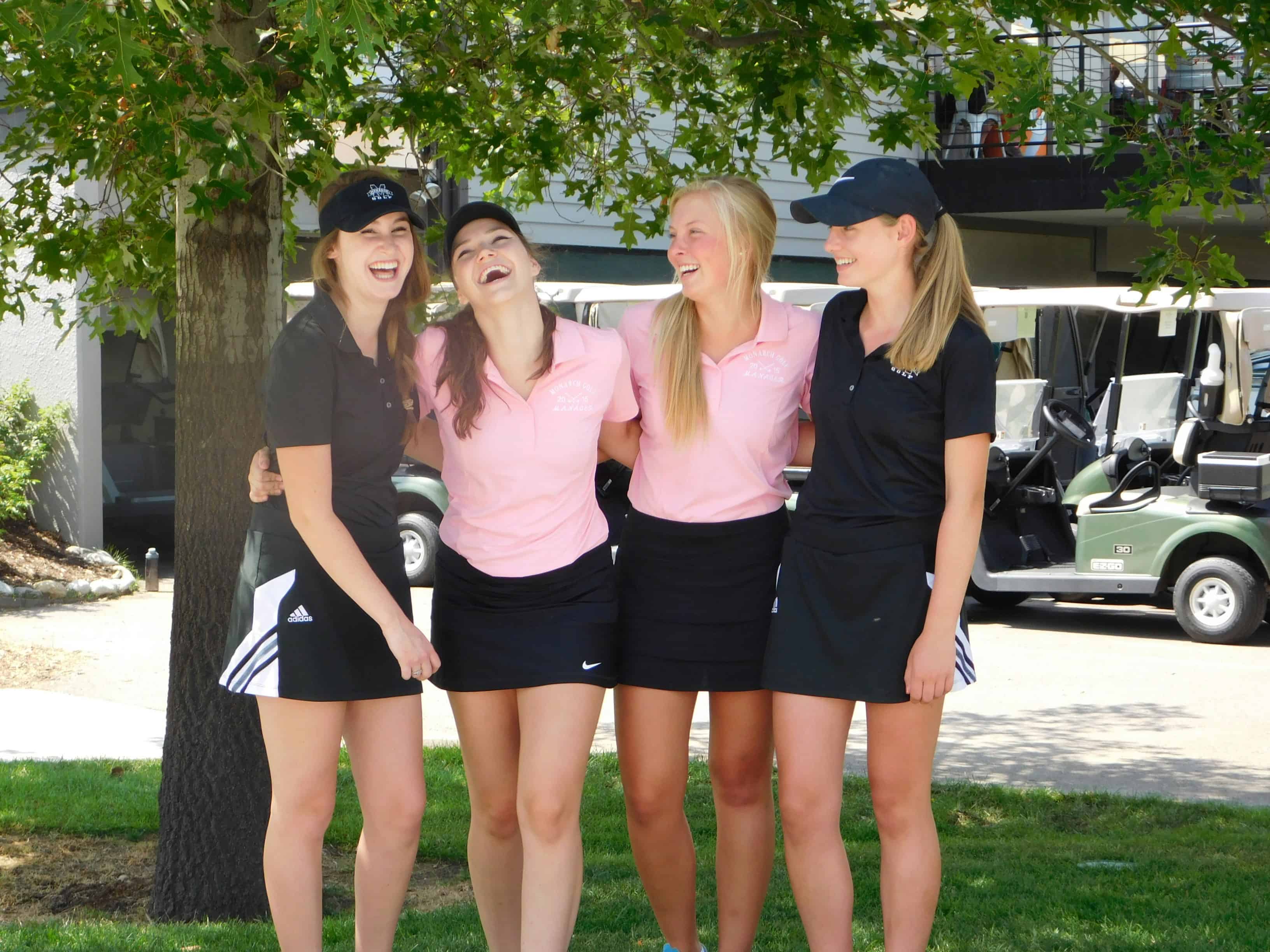 Four friends laughing together on a golf course